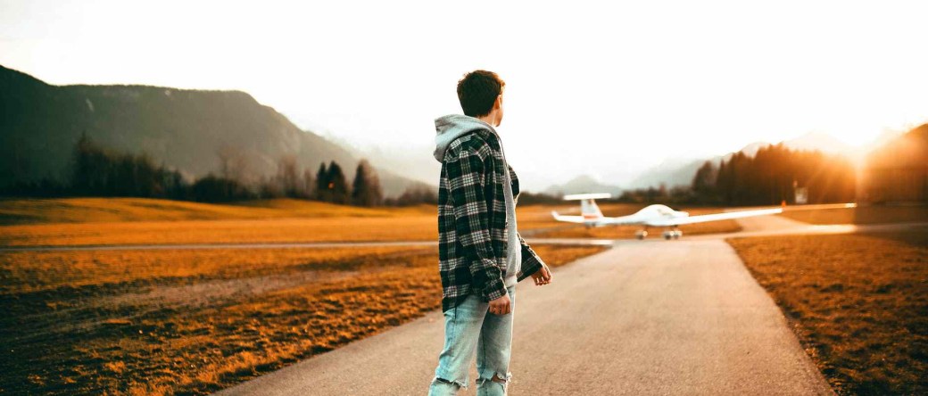 photography of a man wearing gray jacket looking back
