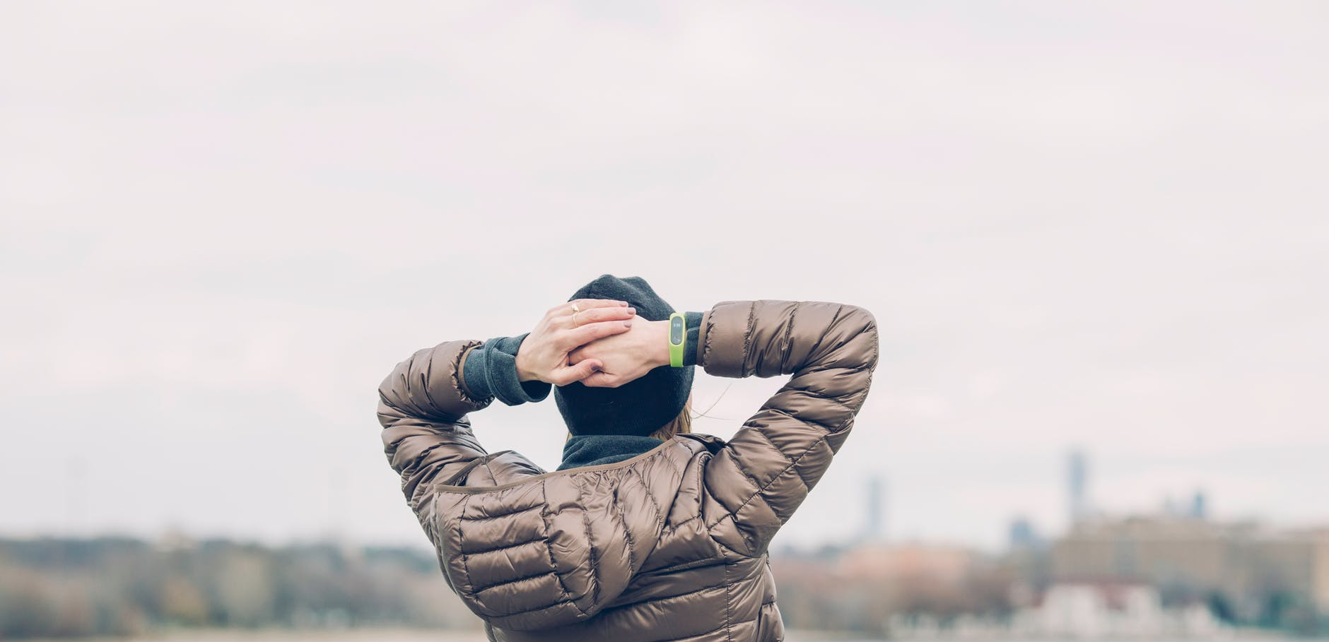 person holding head facing body of water