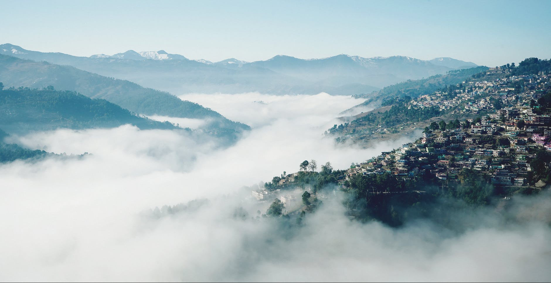 misty valley with town on slope
